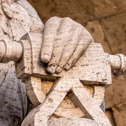 Close-up of the hand of one of the university entrance statues.
