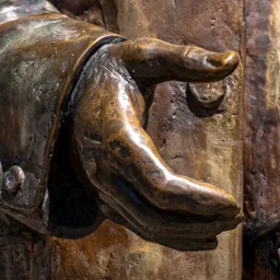 Close-up of the junk dealer's bronze hand.