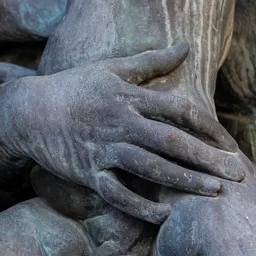 Close-up of the mother's hand supporting the child on her lap.