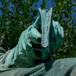 Close-up of Mór Jókai's left hand holding a book on his lap.