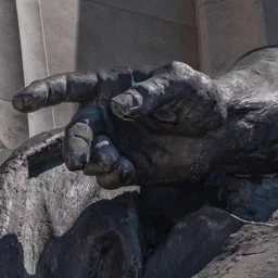 Close-up of the Work allegory's powerful left hand pointing forward.