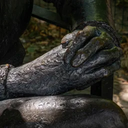 Close-up of Tom Lantos' intertwined hands resting on his knee.