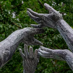 Close-up of several hands from the three female figures.
